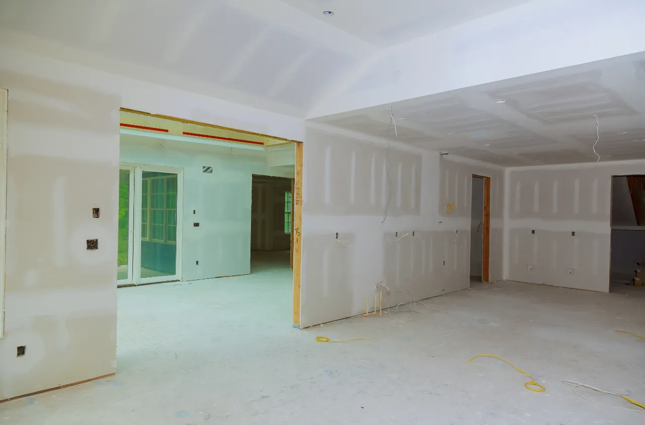 Drywall installer finishing walls on a New York job site